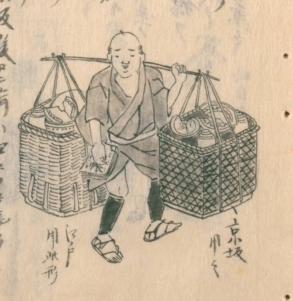 割れた器を詰めた二つの籠を天秤棒で担ぐ焼継ぎ屋。京坂の姿として描かれている。